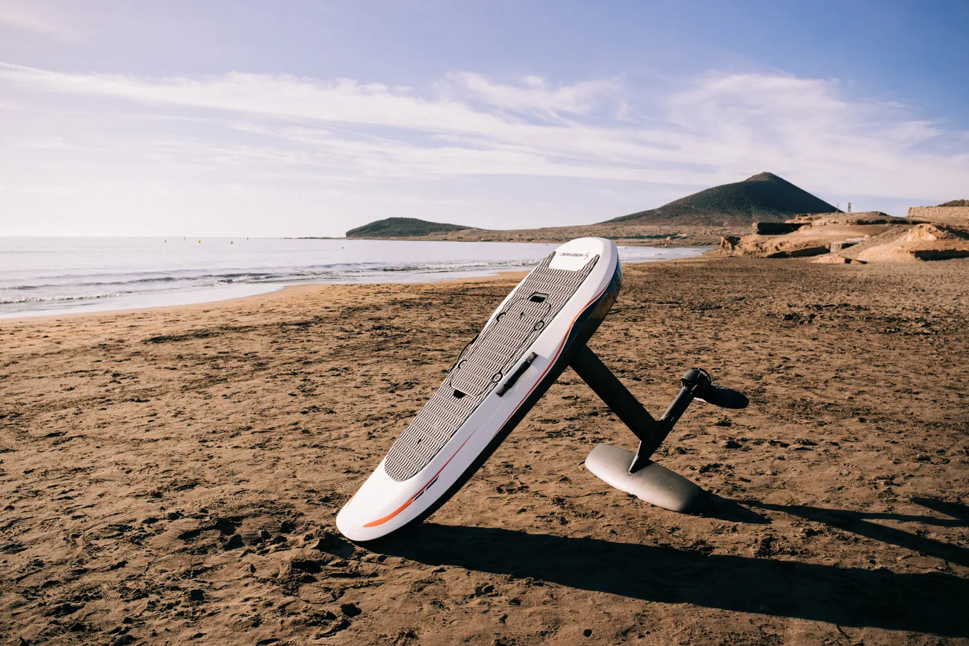 Equipo de eFoil Hobbywing en una playa de arena junto a la costa